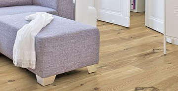 Im Wohnzimmer ist Parkett in Langdielen-Optik verlegt.