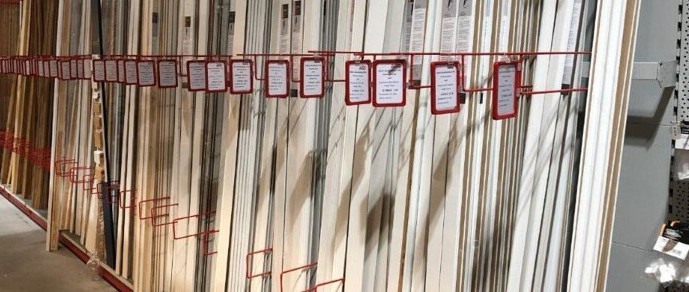 Ein Regal im HolzLand Brinkmann-Markt, gefüllt mit verschiedenen Sockelleisten.