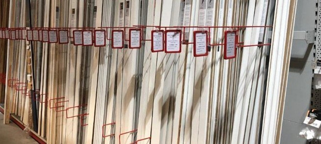 Ein Regal im HolzLand Brinkmann-Markt, gefüllt mit verschiedenen Sockelleisten.
