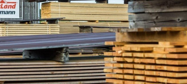 Außenregale im HolzLand Brinkmann, gefüllt mit Kanthölzern unterschiedlicher Größe und Länge.
