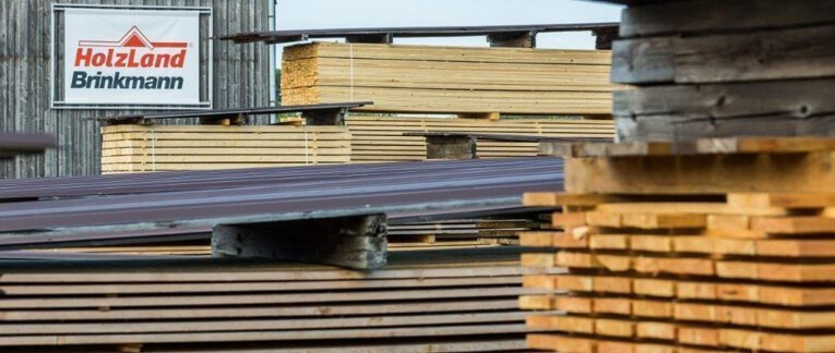 Außenregale im HolzLand Brinkmann, gefüllt mit Kanthölzern unterschiedlicher Größe und Länge.