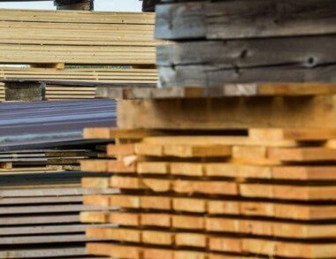 Außenregale im HolzLand Brinkmann, gefüllt mit Kanthölzern unterschiedlicher Größe und Länge.