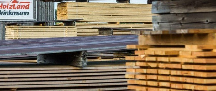 Außenregale im HolzLand Brinkmann, gefüllt mit Kanthölzern unterschiedlicher Größe und Länge.