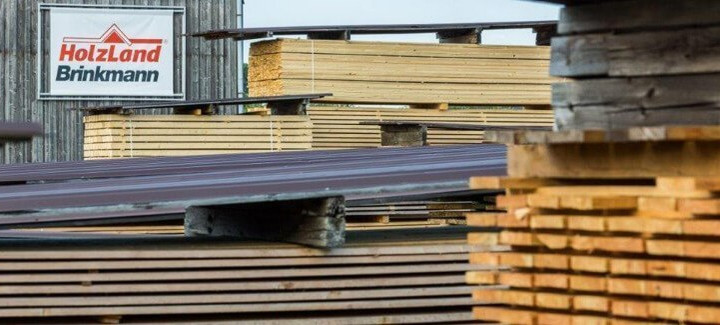 Außenregale im HolzLand Brinkmann, gefüllt mit Kanthölzern unterschiedlicher Größe und Länge.