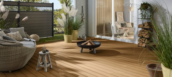 WPC-Terrasse im skandinavischen Stil mit Lounge, Feuerstelle und dekorativen Gräsern.