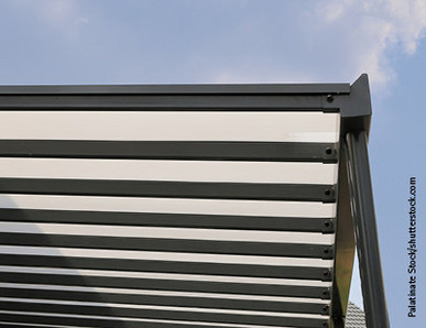 Moderne Überdachung mit transparenter Dacheindeckung aus Kunststoffplatten und stabiler Metallkonstruktion.