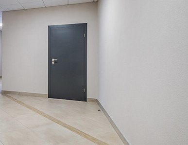 Mehrere anthrazitfarbene Wohnungstüren, Blick vom Treppenhaus.