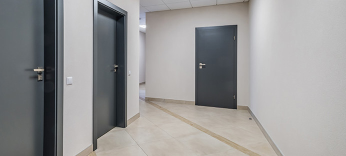 Mehrere anthrazitfarbene Wohnungstüren, Blick vom Treppenhaus.