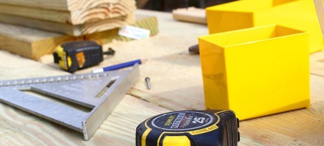 Werkzeuge und Holzbretter auf einer Baustelle – Präzision und Handwerkskunst bei der Holzmontage.