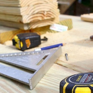 Werkzeuge und Holzbretter auf einer Baustelle – Präzision und Handwerkskunst bei der Holzmontage.