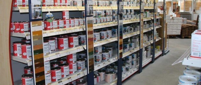 Regale im HolzLand Brinkmann-Markt mit einer großen Auswahl an Farben und Holzpflegeprodukten.
