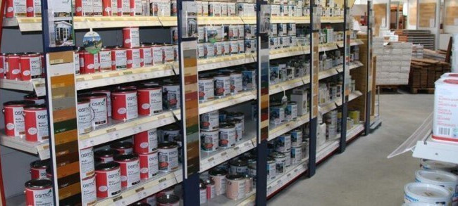Regale im HolzLand Brinkmann-Markt mit einer großen Auswahl an Farben und Holzpflegeprodukten.