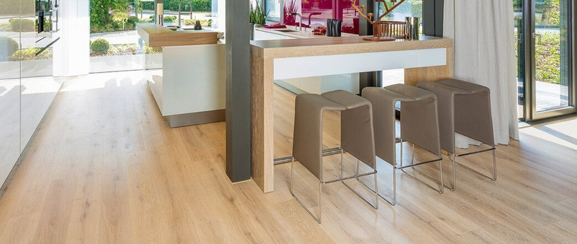 Die Küche ist mit hellem Holzlaminat ausgelegt. Eine Koch- und Essinsel mit drei Hockern lädt zum Verweilen ein.
