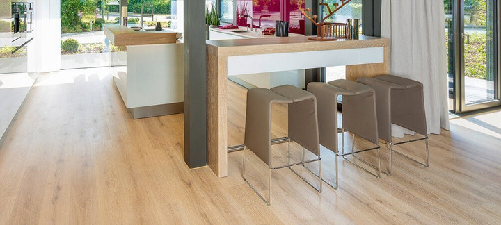Die Küche ist mit hellem Holzlaminat ausgelegt. Eine Koch- und Essinsel mit drei Hockern lädt zum Verweilen ein.